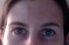 Left eyebrow lower, left eye looks smaller, less open.