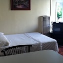 A Full sized Bed, A Twin sized Bed, and a leather couch.