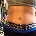 7 months PO. Front view wearing yoga pants. Flat and fit. Remaining stretch marks that could not be removed.